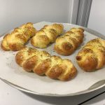 Five loaves of challah bread on a platter