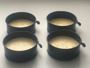 Four 4-inch spring-form pans with the filling mixture in them