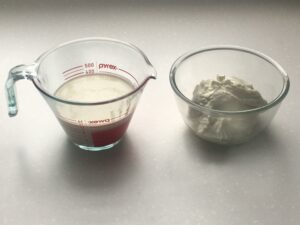 A measuring cup with 350 millilitres of whipping cream and a bowl with 350 grammes of Greek yoghurt