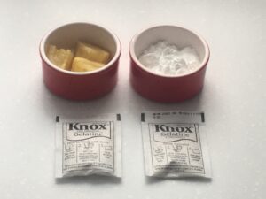 Small dishes with lemon quarters and icing sugar, respectively, and two gelatine packets