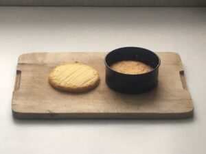 A spring-form pan with the top half of the cake inside and the bottom, inverted, sitting next to it