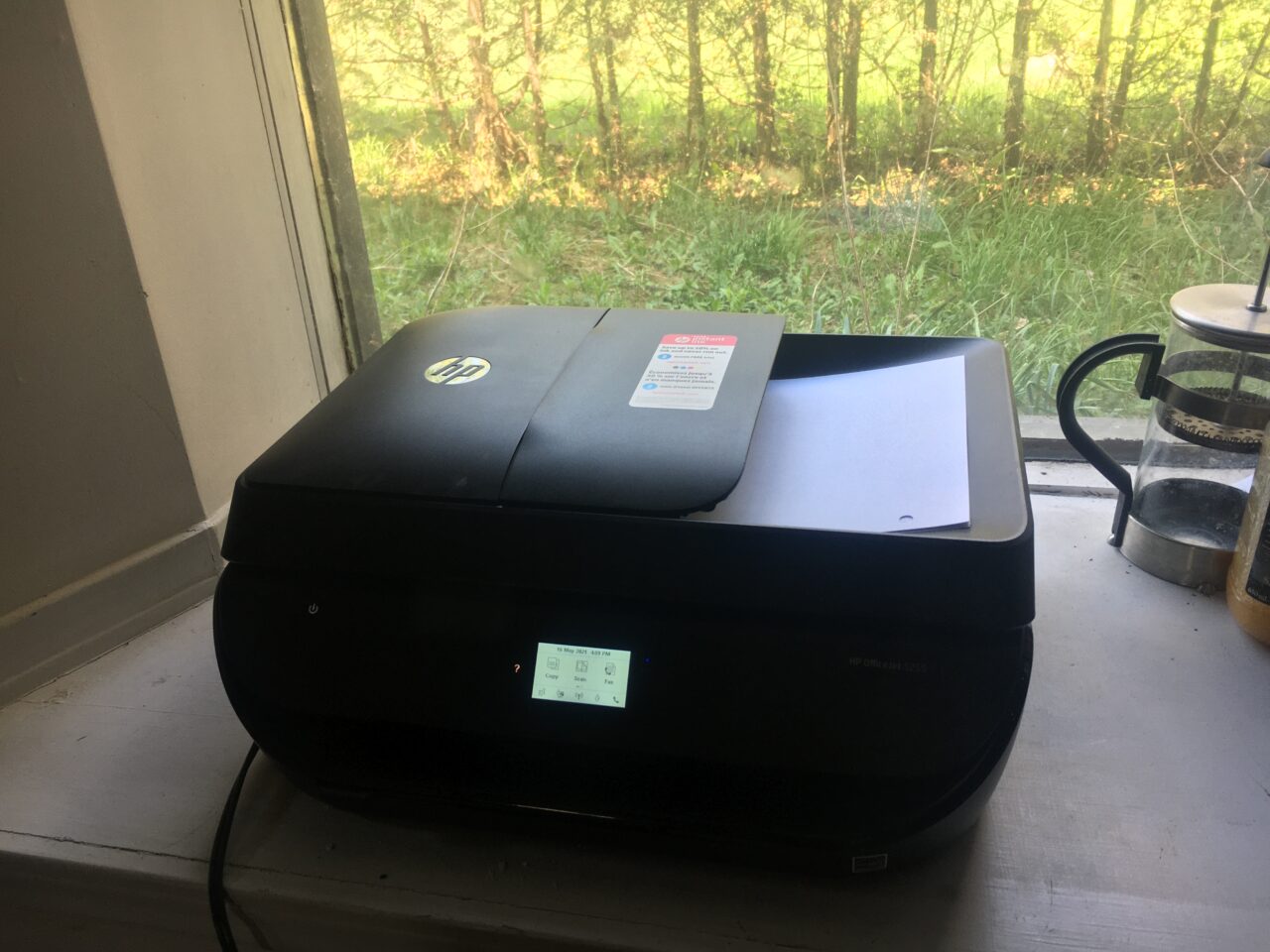 An HP Officejet 5355 sitting in a window box.